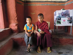 Ein Junge und ein kleiner Mönch im Hauseingang